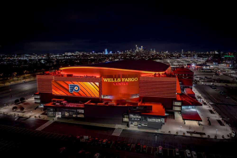 Wells Fargo Center, Philadelphia, illuminated in Flyers colors at night.